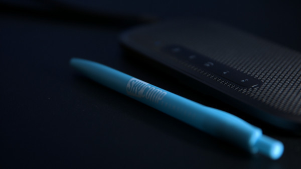 A closeup of a Skycomp Pen and A Lenovo 700 Mini Bluetooth Speaker