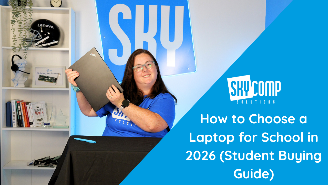Smiling woman in a blue SkyComp shirt holds a laptop at a desk, with a blue promotional banner that reads: 'How to Choose a Laptop for School in 2026'.