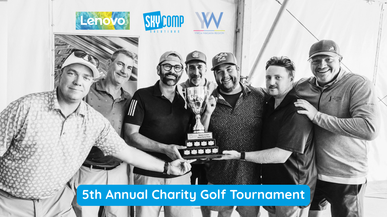 Blog Post 1 1 | Skycomp Solutions | Skycomp Solutions Seven men pose with a trophy at a charity golf tournament, banners of Lenovo, SkyComp, and YW visible in the background.